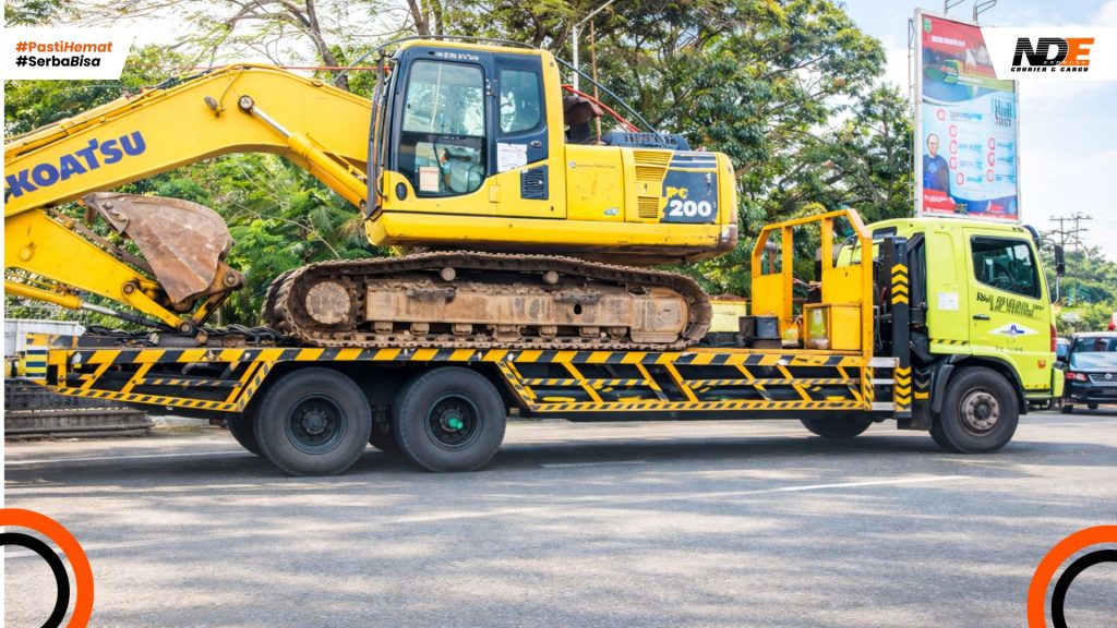 Pengiriman alat berat excavator Komatsu PC200 menggunakan truk lowbed untuk kebutuhan proyek dan industri.